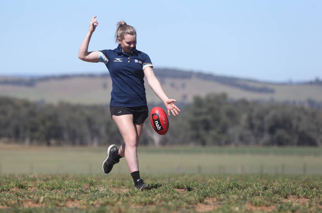 Alyce Parker has a kick of the footy at home on the family farm near Cookardinia.
