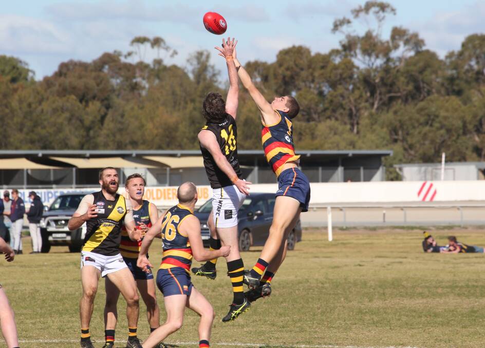 UP FOR GRABS: Wagga Tigers' Matt Noonan and Leeton-Whitton's Kyle Pete fly high at Leeton Showground on Saturday. Picture: Anthony Stipo