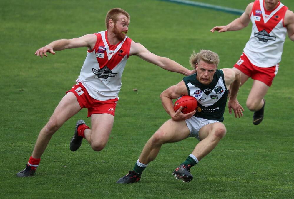 GOTCHA: Griffith defender James Taylor grabs a hold of Coolamon's Jeremiah Maslin in the second semi-final at Narrandera Sportsground on Saturday. Picture: Les Smith