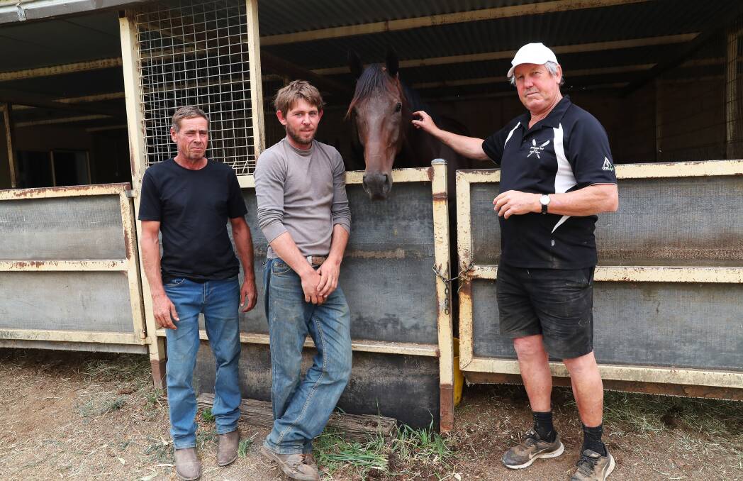 Graham Byatt, Simon Grimson and Gary Colvin with one of Byatt's horses that was moved away from Tumbarumba on Friday. Picture: Emma Hillier