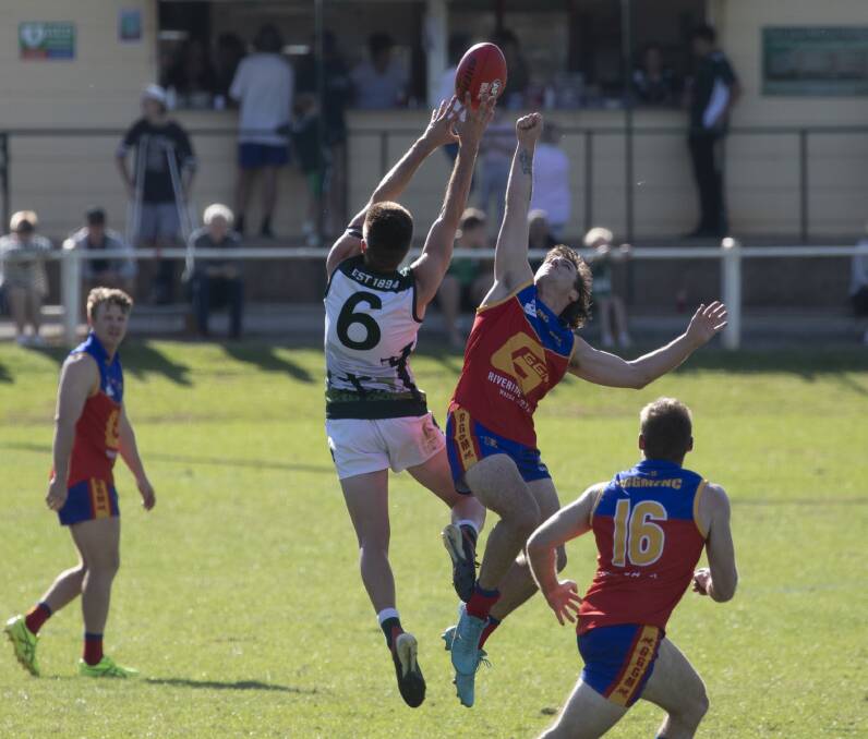 UP FOR GRABS: Coolamon's Cooper McKelvie flies high to mark despite the best efforts of Ganmain-Grong Grong-Matong's Tom Anderson on Sunday. Picture: Madeline Begley