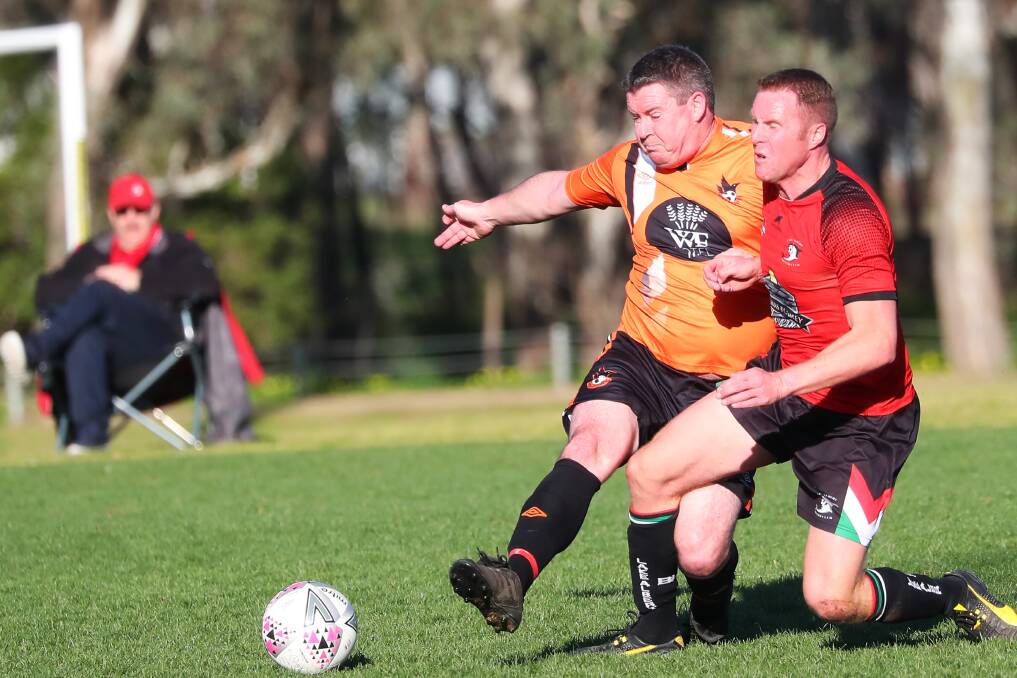 STRONG CHALLENGE: Wagga United's Adam Holmes and Lake Albert's Duncan Brodie clash in the Pascoe Cup game at Rawlings Park on Sunday. Picture: Emma Hillier