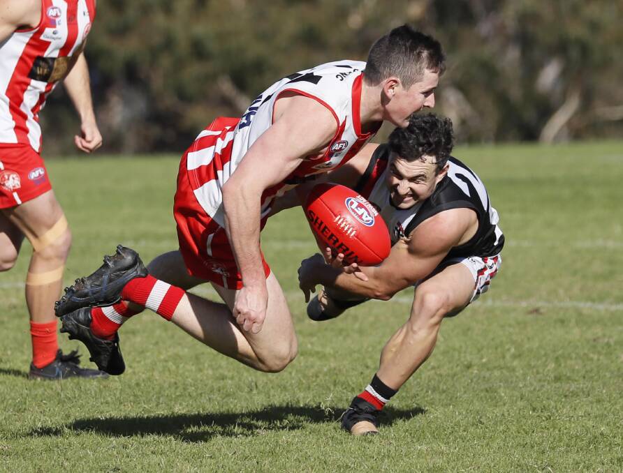 HARD AT IT: Charles Sturt University's Max Findlay looks to get a handball away despite running into North Wagga's Dylan McDermott in the Farrer League game at Peter Hastie Oval on Saturday. Picture: Les Smith