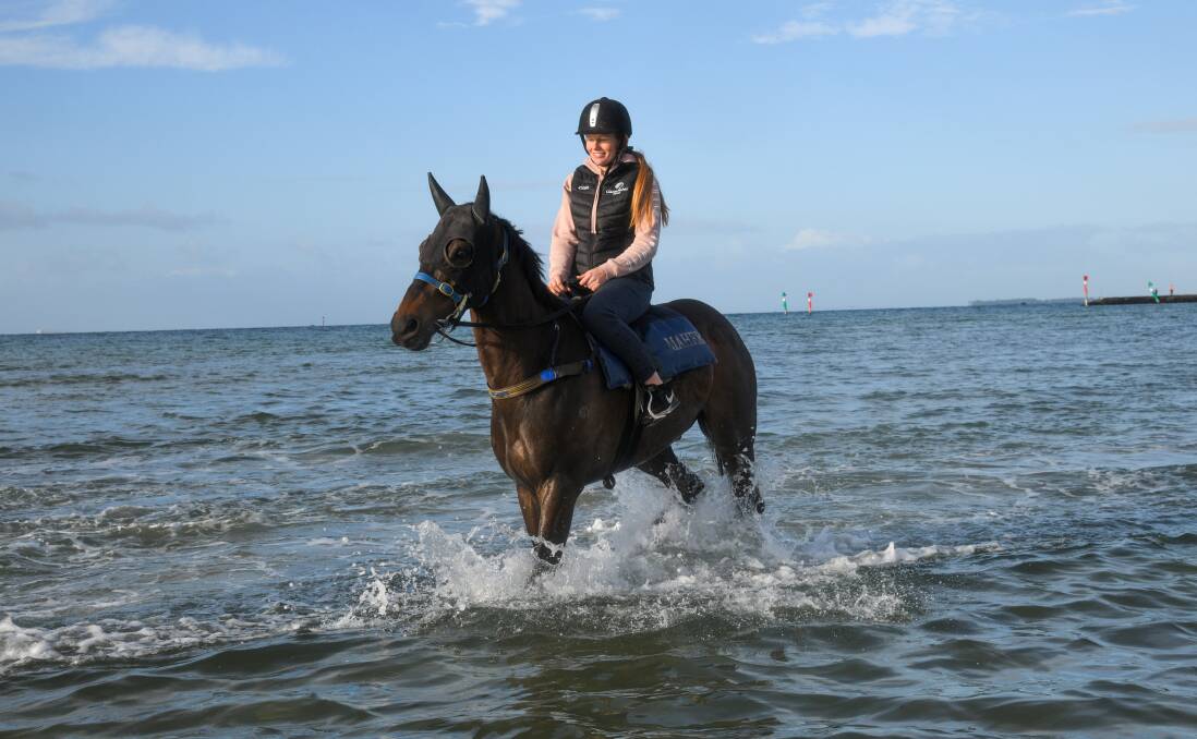 QUICK SPLASH: Ashley Jarvis takes Floating Artist for a walk at Altona Beach ahead of the Melbourne Cup on Tuesday. Picture: Getty Images