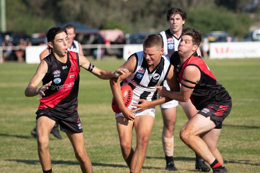 The Rock-Yerong Creek co-captain Cooper Diessel tries to break the tackle of Marrar coach Cal Gardner (right) and Caleb Walker (left) at Langtry Oval on Saturday. Picture by Madeline Begley
