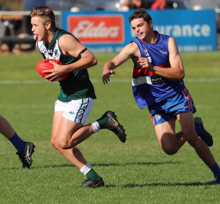HAPPY: Coolamon's Cooper McKelvie runs away from Turvey Park's Ryan Shaw to kick a goal at Kindra Park on Sunday. Picture: Les Smith