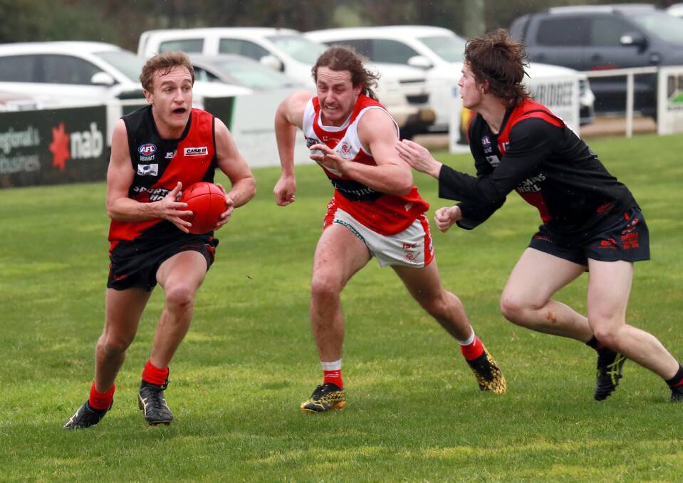 UNDER THE PUMP: Marrar's Jack Reynolds looks to send the ball forward as teammate Toby Lawler tries to stop a closing Nick Perryman for Collingullie-Glenfield Park at Langtry Oval on Saturday. Picture: Les Smith
