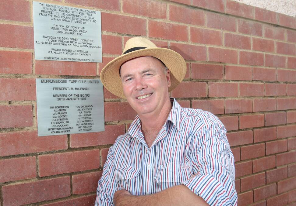 Stuart Lamont at the plaque that marks the opening of the new racecourse and grandstand at Murrumbidgee Turf Club.