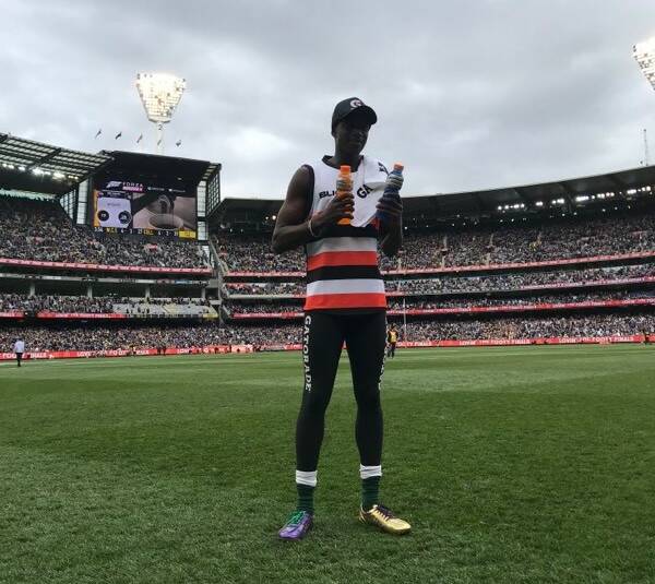 CENTRE OF ATTENTION: Godfrey Okerenyang celebrates his victory in the AFL grand final sprint at half-time at the MCG on Saturday.