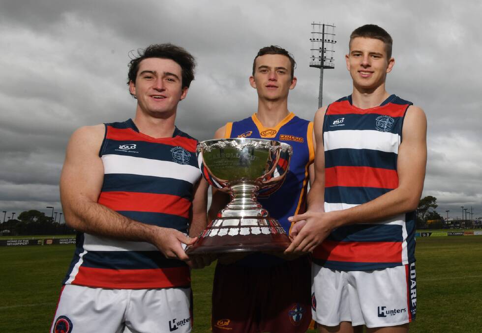 BATTLE READY: Kildare co-captains Ryan Allen and Will Reinhold show off the Carroll Cup with Mater Dei captain Lachie Johnson at Robertson Oval on Tuesday. 