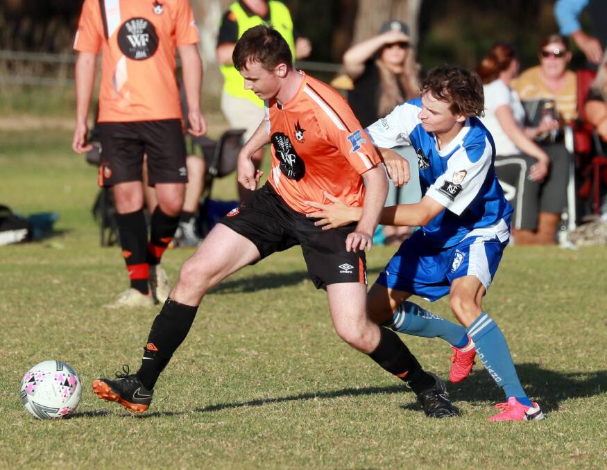 UNDER THE PUMP: Wagga United's Cooper Floyer-Kell gets his foot to the ball despite pressure from Tolland's Jamey Lenko at Rawlings Park on Sunday. Picture: Les Smith