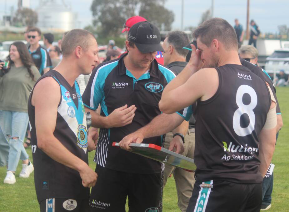Sam Fisher (middle) talks through the team with Jack Fisher (left) and Jack Harper (right) at three-quarter-time of the first semi-final on Sunday. Picture by Matt Malone