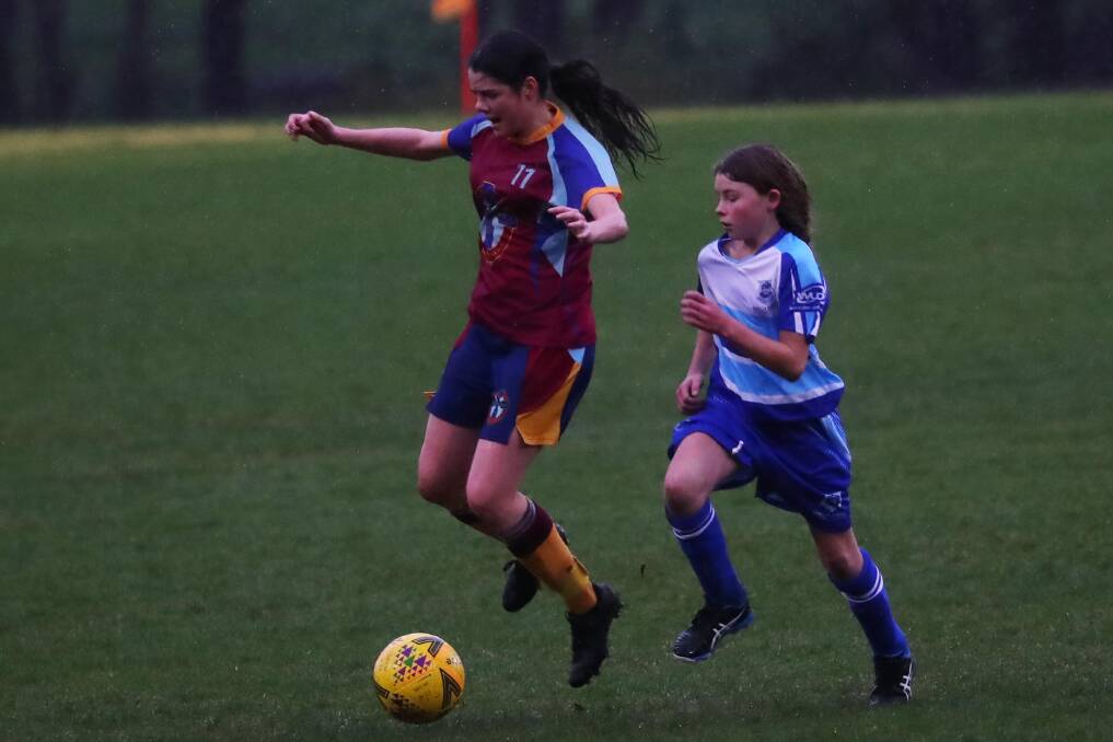 TOUGH CONDITIONS: Mater Dei Catholic College's Tess Vaccari takes on her Wagga High School opponent in the Shipard Shield contest at Rawlings Park on Monday. Picture: Emma Hillier