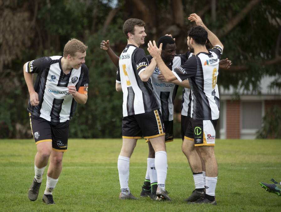 HAPPY DAYS: Wagga City Wanderers celebrate a Morris Kadzola goal in a recent game. Kadzola scored three times in the shock win over Tuggeranong United on Saturday. Picture: Madeline Begley