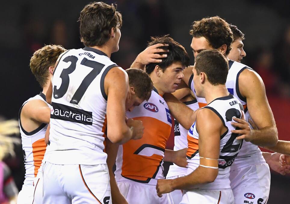 POPULAR: Matt Kennedy is flanked by Giants team mates after kicking one of his three goals against Essendon on Sunday. Picture: Getty Images