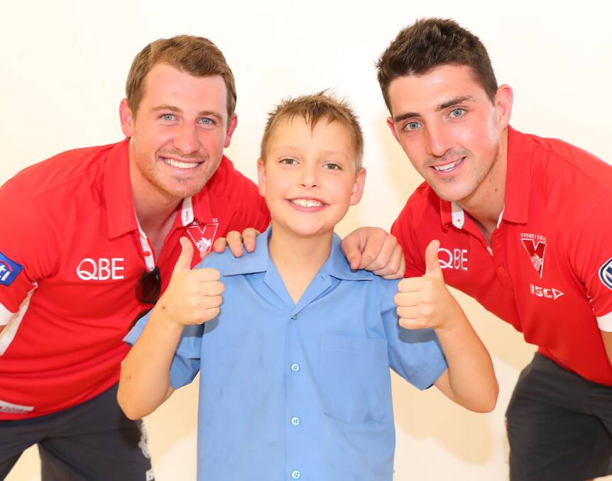 Sydney players Harry Cunningham and Colin O'Riordan with Hugo Gray at Holy Trinity Primary School during an AFL Community Camp back in 2018.