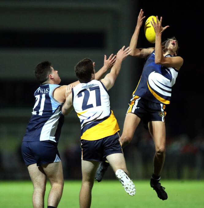 COURAGE: Kooringal High School's Hugh Schmetzer flies back to take a mark in front of teammate Mitch McCauley and Wagga High's Toby Meriton in the Carroll Cup at Robertson Oval on Wednesday night. Picture: Les Smith