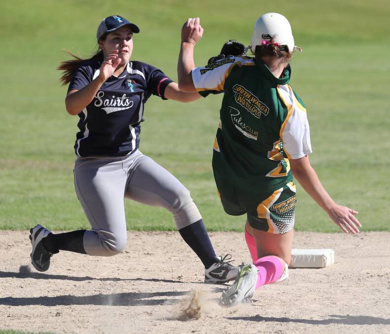 OUT: South Wagga Warriors' Jess Swaysland is tagged out by Saints' Seona Dwyer in the Wagga A grade softball game earlier this month. The two teams will meet again on Saturday. Picture: Les Smith