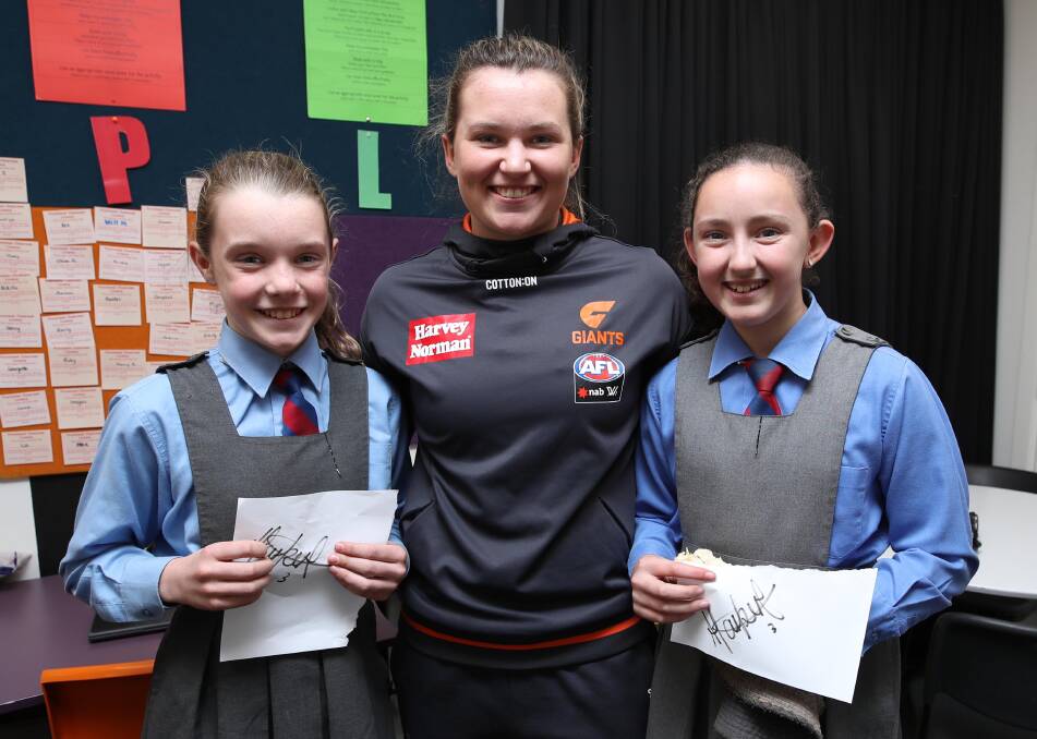 ROLE MODEL: GWS Giants footballer Alyce Parker, from Cookardinia, signs autographs for Zoe Scott, 12 and Cassie Budde, 11, at Mater Dei Primary School on Wednesday. Picture: Les Smith