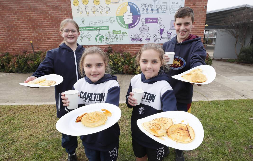 FUN-DRAISER: Grace Jackson, 11, Natalie Spokes, 11, Abbie Spokes, 11, and Hayden Gardiner, 12, show off the pancakes and hot chocolates at Wednesday's fundraiser at Kooringal Public School. The four students have been selected to represent NSW at the national carnival in Adelaide in August. Picture: Les Smith
