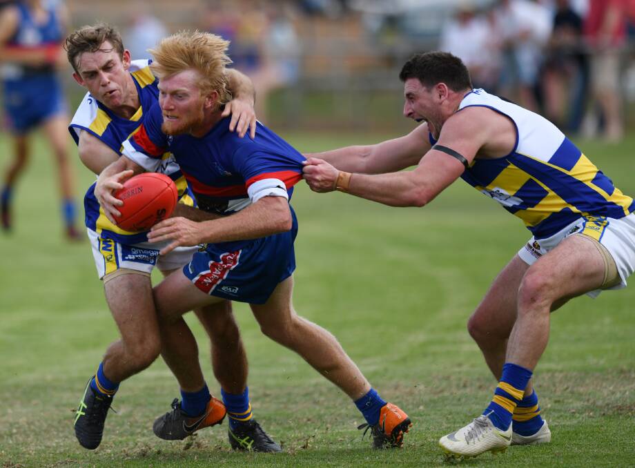 UNDER THE PUMP: Turvey Park co-coach Jeremy Sykes gets tackled by MCUE's Pat Killalea and Dom Bunyan at Maher Oval on Saturday.