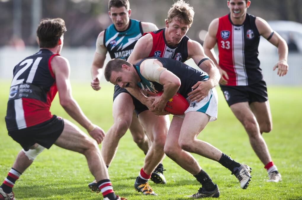 Ash Harris lays a tackle for Ainslie.