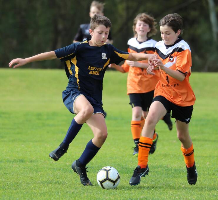 Junee's Tom Collins-McAlister and Wagga United's Samuel Baggett compete in a junior soccer game last year. Picture: Les Smith
