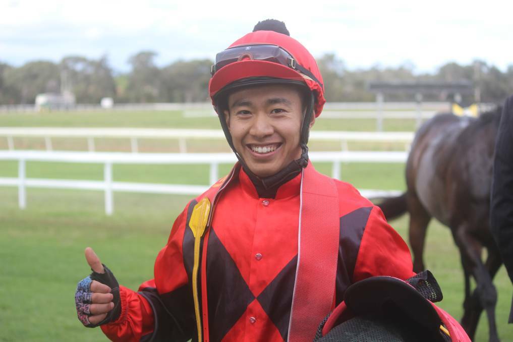 ALL SMILES: Apprentice jockey Qin Yong gives his approval after guiding Kentucky Flyer to victory in the Jungle Juice Cup at Cessnock. Picture: Stephen Bisset
