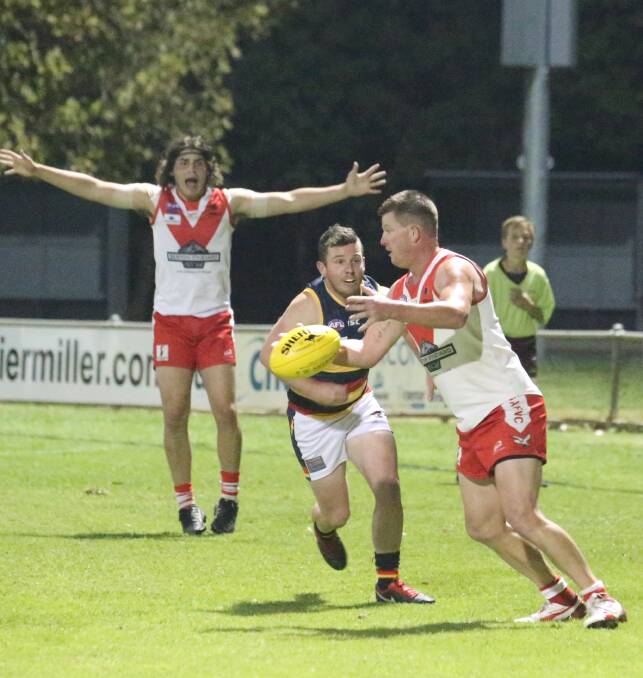 CRAFTY: Griffith's Mick Duncan gets a kick away despite pressure from Leeton-Whitton's Reece Maguire at Exies Oval on Saturday night. Picture: Anthony Stipo
