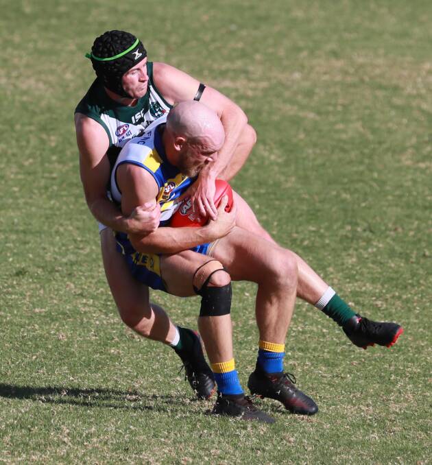 GOTCHA: MCUE match-winner Brayden Ambler is wrapped up by Coolamon's Marshal Macauley at Kindra Park on Sunday. Picture: Les Smith