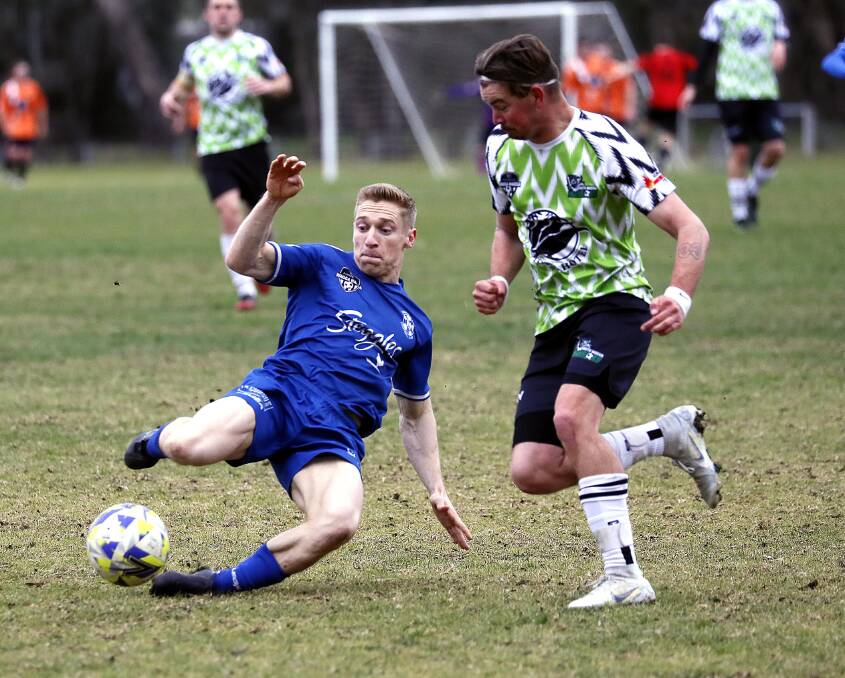 CLEARING KICK: Hanwood's Andy Gamble clears the ball from South Wagga's Damon Watson in the Pascoe Cup game at Rawlings Park on Sunday. Picture: Les Smith