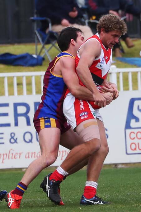 WRAPPED UP: Jayden Klemke, with his hamstring taped, is tackled by Ganmain-Grong Grong-Matong's Josh Bubnich in last Saturday's qualifying final at Robertson Oval. Picture: Emma Hillier