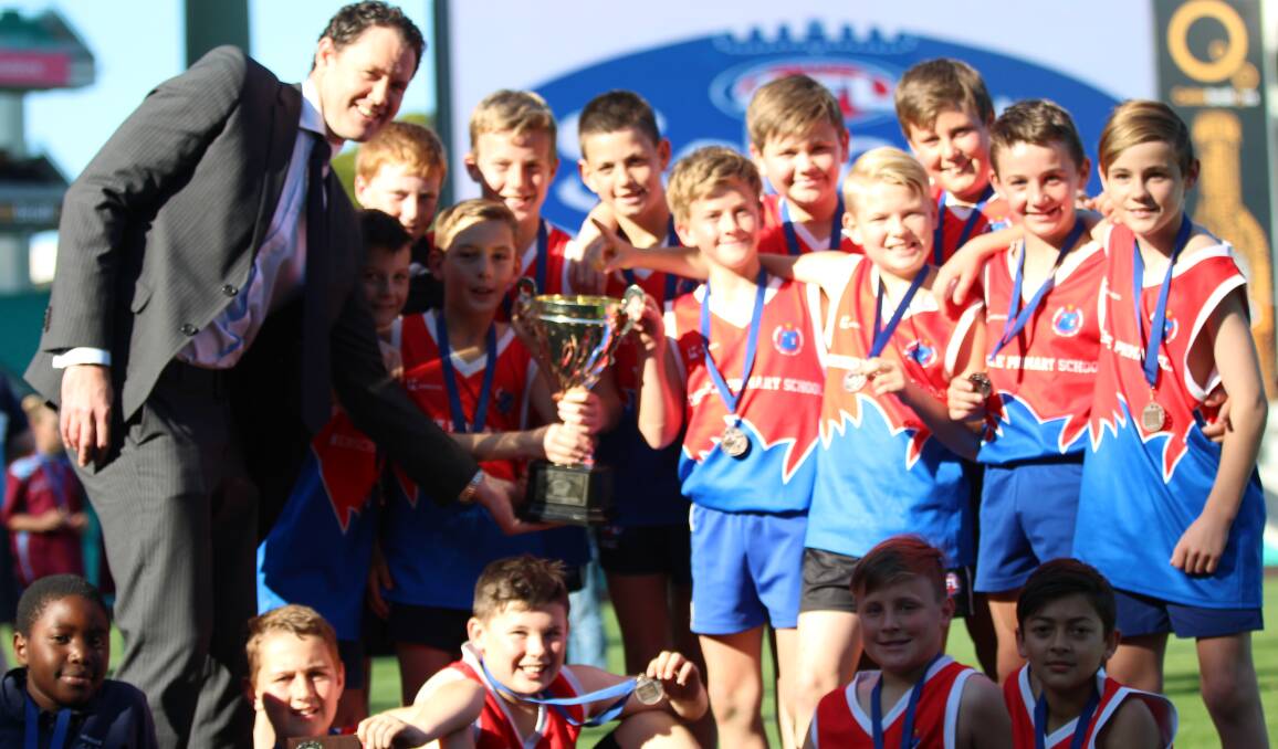 CHAMPIONS: AFL NSW-ACT chief executive Sam Graham presents Henschke Primary School with the Paul Kelly Cup. 