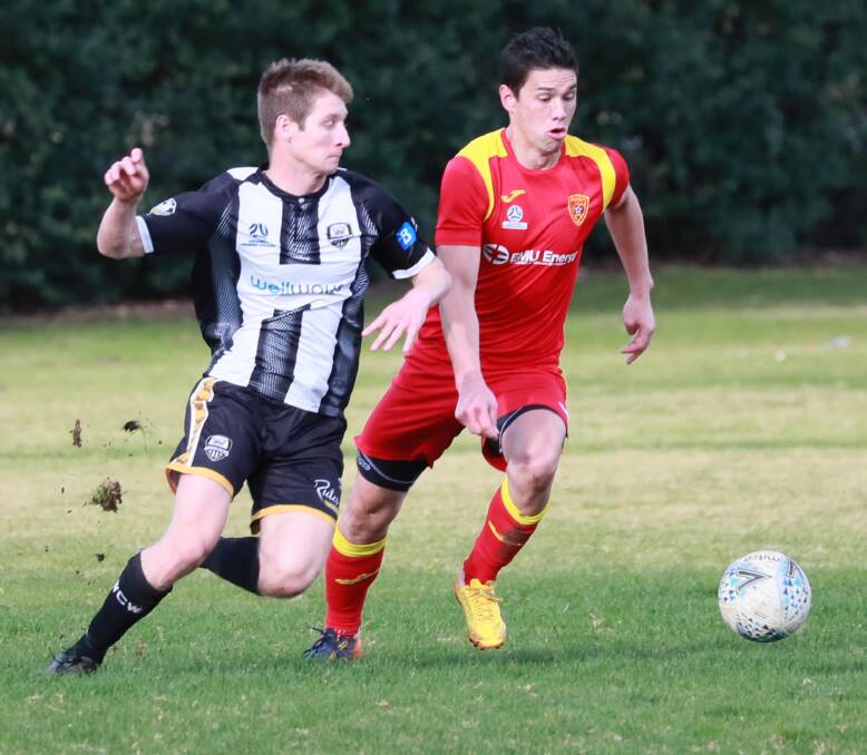 OUT: Wagga City Wanderers' James Klein battles it out with Queanbeyan City's Mark Shields in a game earlier this month. Klein will miss this week's game against Brindabella. Picture: Les Smith