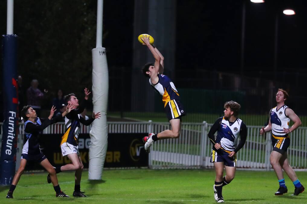 HIGH FLYER: Kooringal High School's Tomas Matheson takes a strong mark in the Carroll Cup game against Wagga High School at Robertson Oval on Monday night. Picture: Emma Hillier