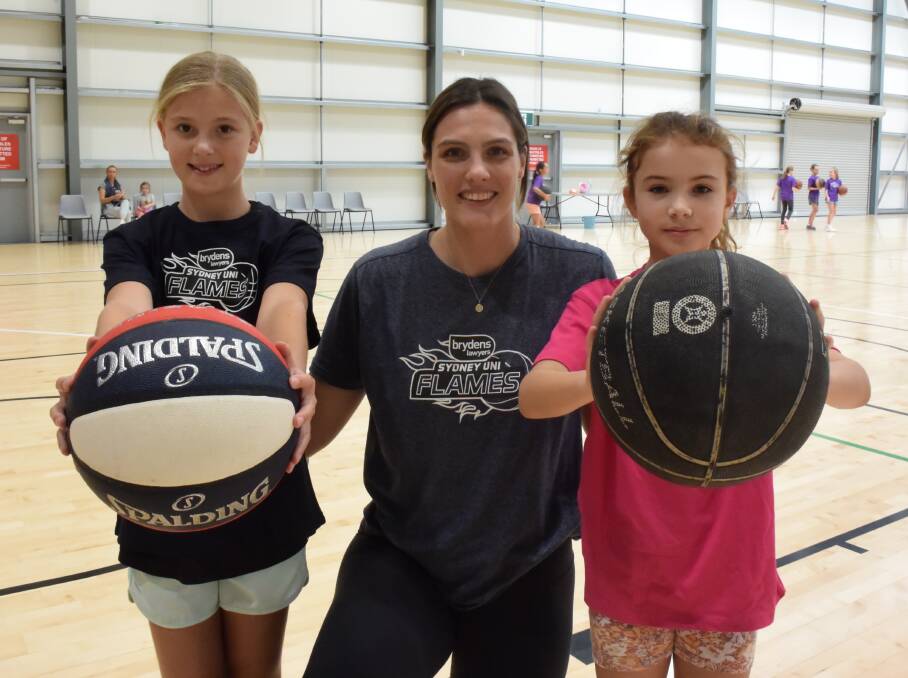 NEXT GENERATION: WNBL star Lauren Scherf teaches a thing or two to Gemma Hugo, 10, and Daisy Joyce-Spencer, 10, at Sydney Flames' 'Her Flame Burns Bright' clinic at Equex Centre on Monday. Picture: Matt Malone