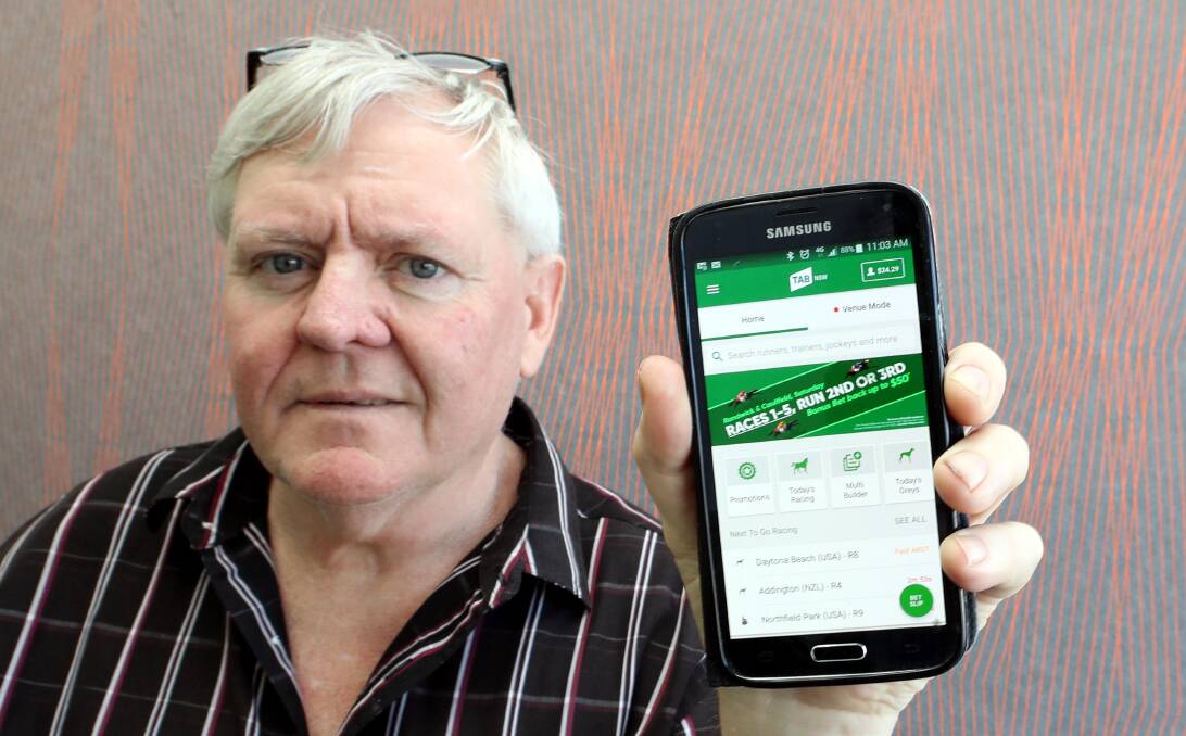 READY TO GO: Wagga punter Mark McKenzie with his TAB app, that he purchased his winning Kosciuszko ticket on.