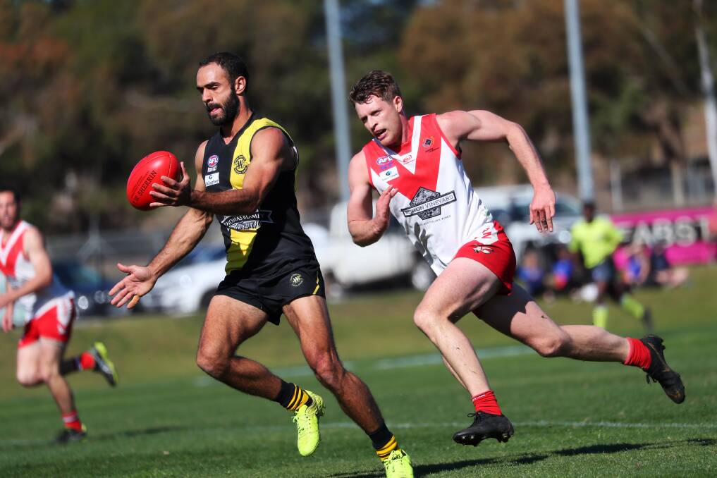 GOT THROUGH: Jesse Manton gets his kick away despite pressure from Griffith's James Toscan at Narrandera Sportsground on Saturday. Manton kicked two goals for Tigers in the loss. Picture: Emma Hillier