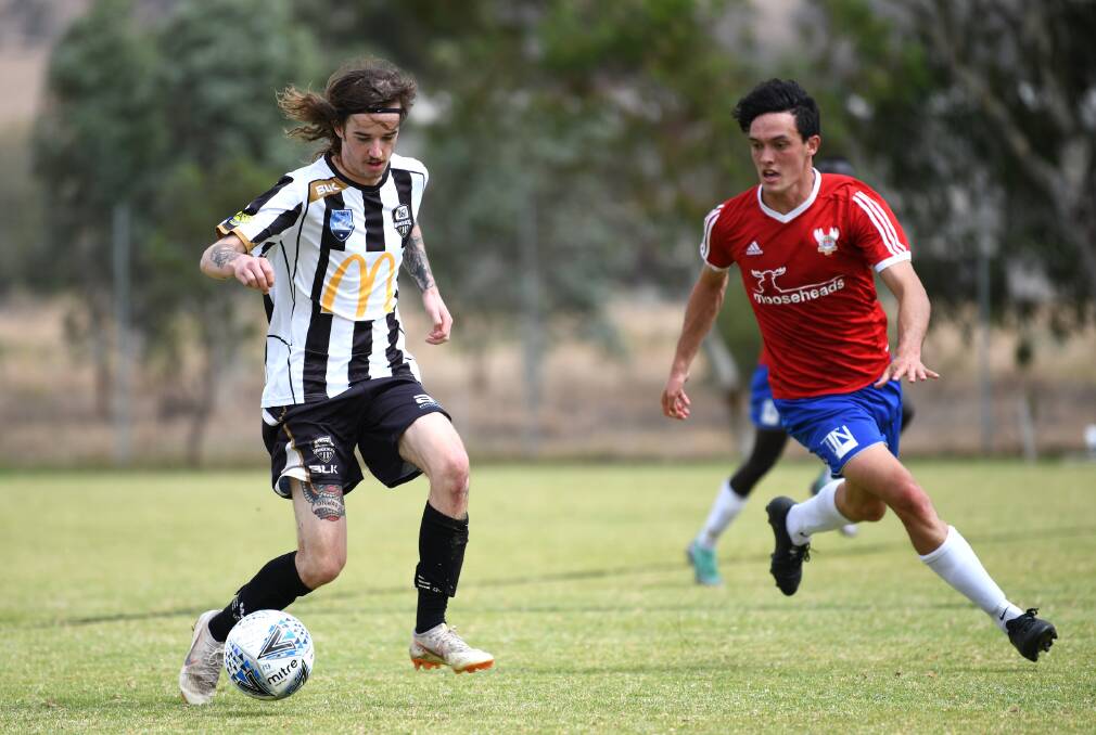 UNDER PRESSURE: Wagga City's Caylum Barber is approached by Canberra's Rua Cullen in the FFA Cup match at O'Connor Park in Cootamundra on Saturday.
