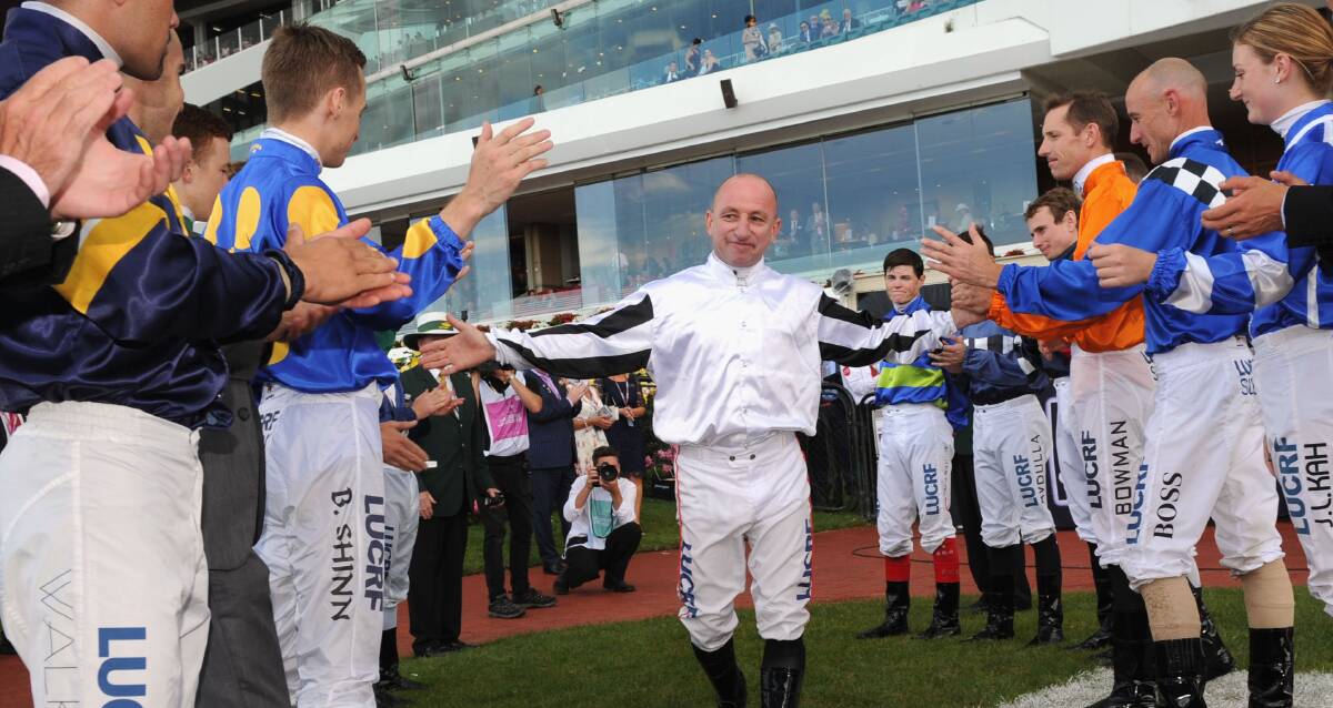 ONE OF A KIND: Jockeys form a guard of honour to farewell Jim Cassidy at his last day of riding on Oaks Day at Flemington last November. Picture: Getty Images