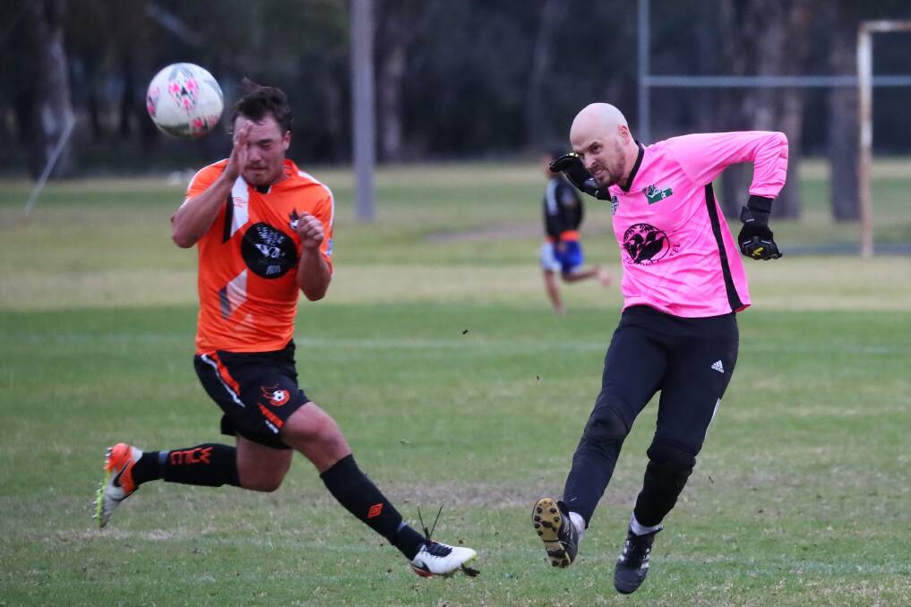 SAVED: South Wagga goalkeeper Brett Scammell blasts the ball past Wagga United's Kai Watts in their 2-2 draw at Rawlings Park on Sunday. Picture: Emma Hillier