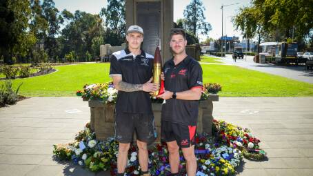 The Rock-Yerong Creek vice-captain Will Adams and Marrar coach Cal Gardner with the shell that be will played for in Saturday's ANZAC Challenge at Langtry Oval. Picture by Bernard Humphreys
