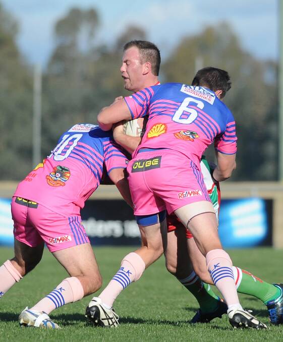 FOR RICK: Junee's Mark Halliburton and Matthew Hands take down Brothers' Aaron Wynne during the 2017 Rick Keast Memorial Shield clash.