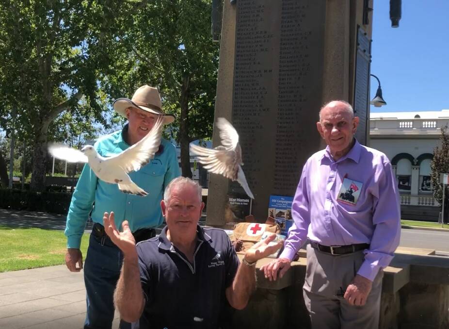 TAKING FLIGHT: Bill Boydell of the Wagga Pigeon Club releases two racers with Mick Bachelor (left) and John Ploenges (right) from the Riverina Light Horse committee. Picture: Emma Horn