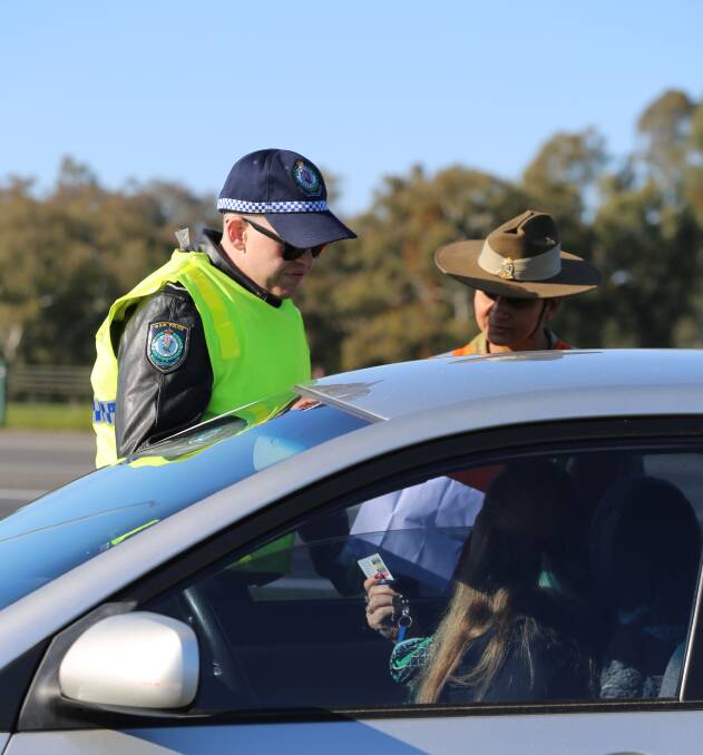 Soldiers and police check cars on their way through the border cross at Albury. Pictures: NSW Police