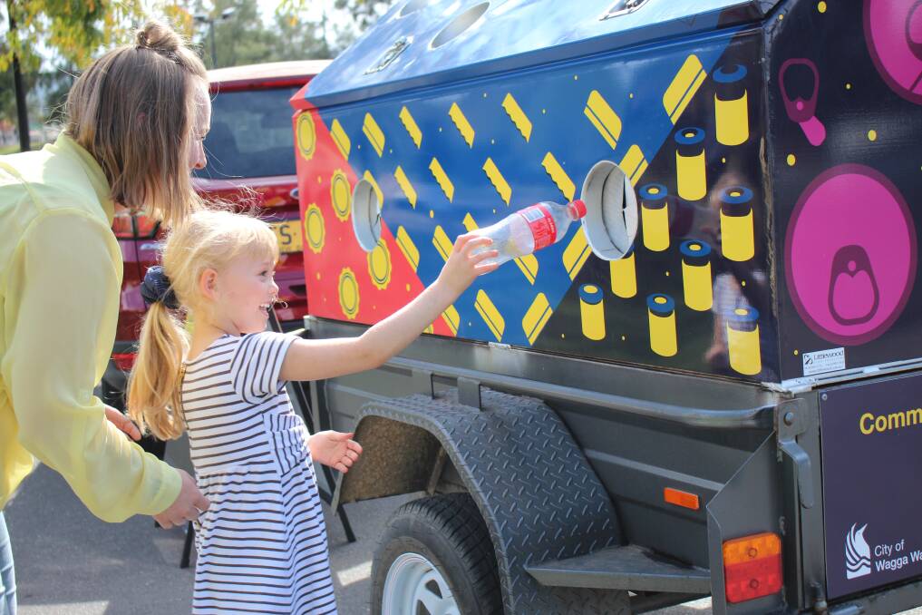TRAILER RETURNS: Five-year-old Tilly Viski becomes the first person to throw a bottle into the bulk-return trailer. Picture: Emma Horn