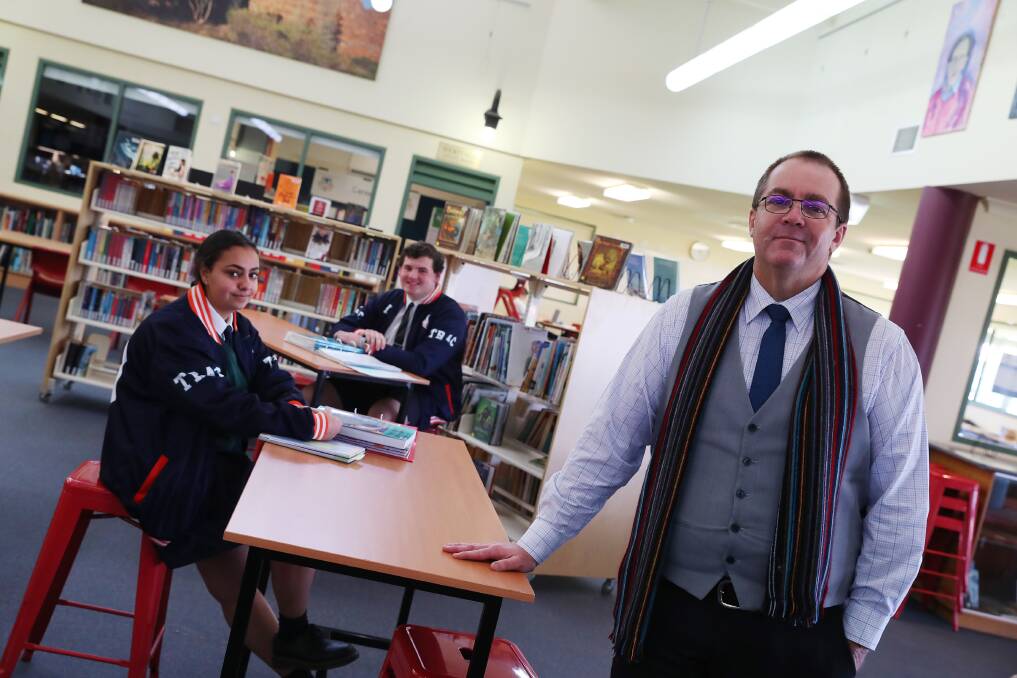 SCHOOL BELL: Marina Gabra and Jordan Hawke, both 17, with principal Paul Humble in the school library after returning for term 2. Picture: Emma Hillier