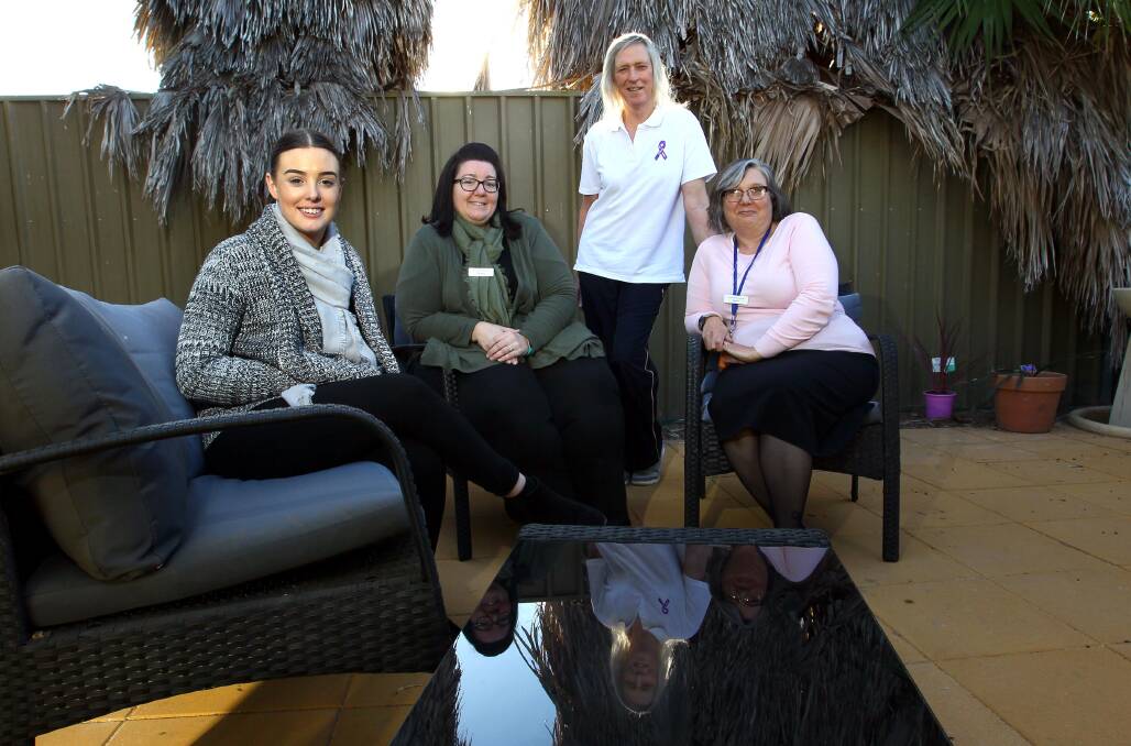 Jenny Davis (standing) with fellow support workers inside the serenity garden created at the women's refuge.