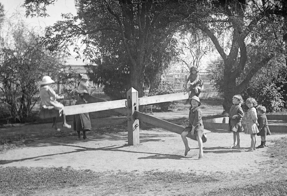THROUGH HISTORY: Children on the double see-saw in Newtown Park circa 1920. Now the site of Collins Park. Picture: Regional Archives, Pym Collection RW2735/5.