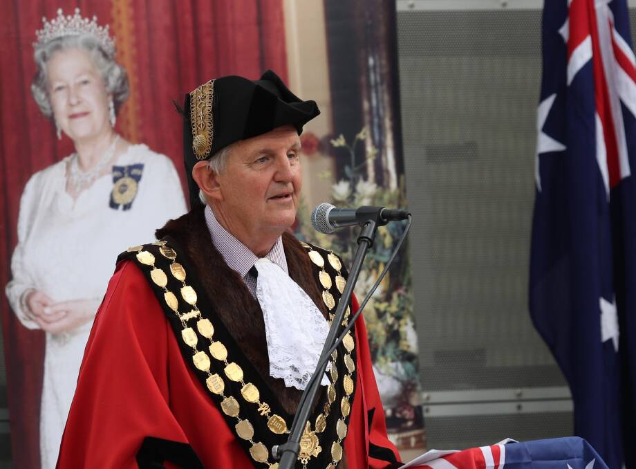 Wagga mayor Greg Conkey performs a citizenship ceremony in the open air of the council chambers forecourt.